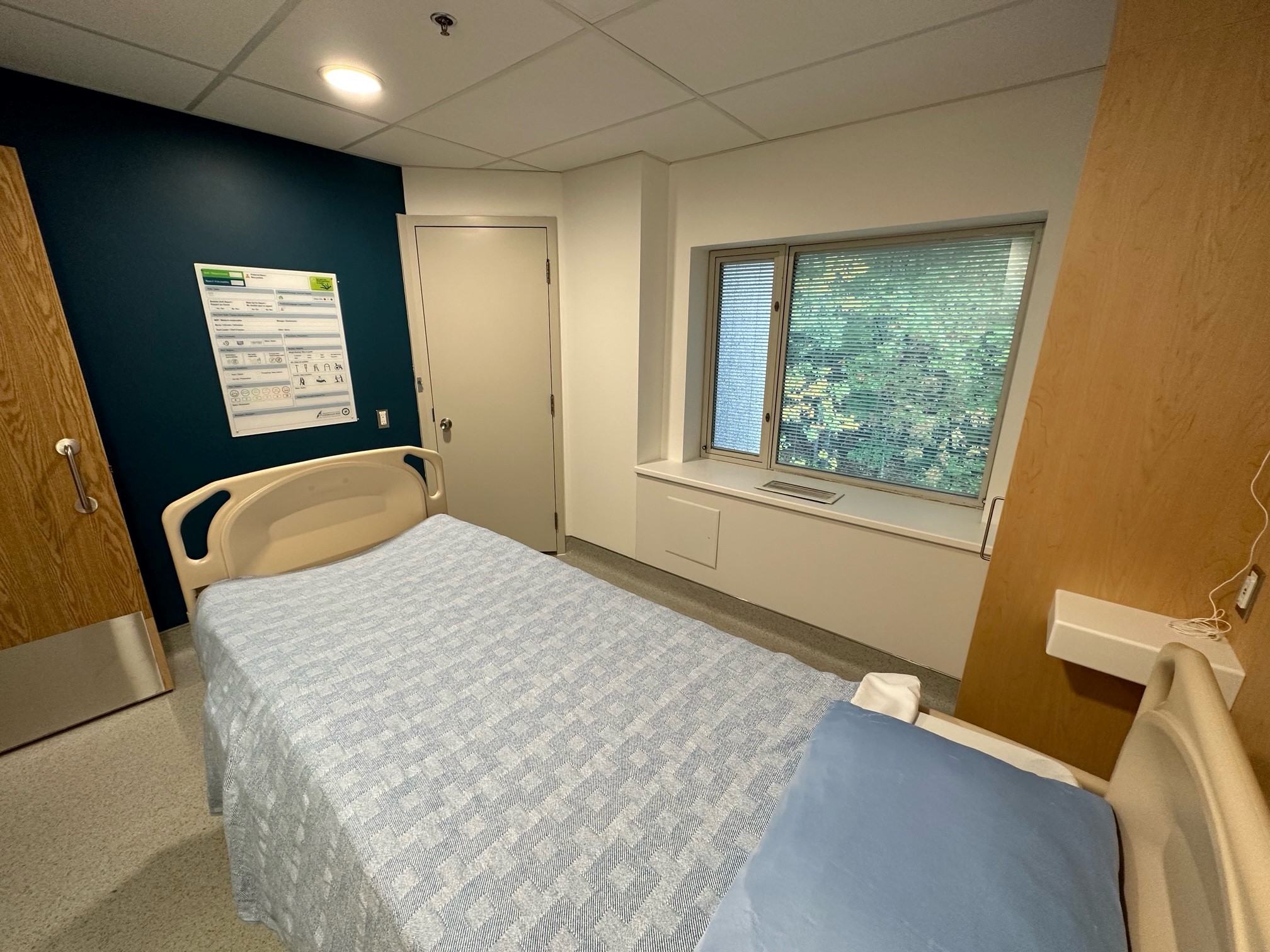 A hospital room showing a bed, and a window