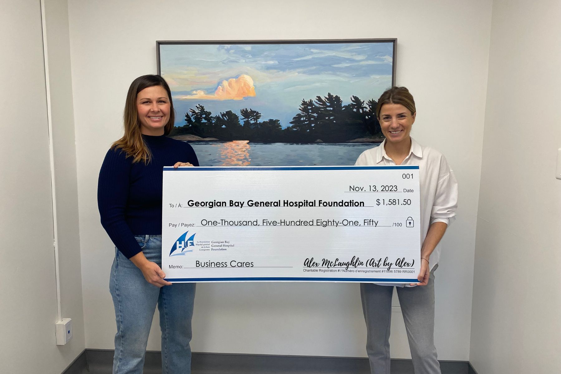 Two women hold a giant cheque for GBGH Foundation for $1,581,50 from Alex McLaughlin - Art by Alex