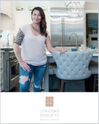A woman in a white t-shirt and ripper jeans with her arm on a blue tufted bar stool. Below is the Lindsay Schultz logo