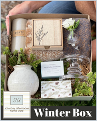 A gift box with a candle, glassware and boxes with Saturday Afternoons Winter Box written underneath