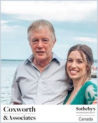 An older grey haired man and a young blond women in green pose with the bay behind them. Coxworth & Associates is below