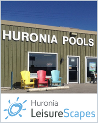 Green building with yellow, red and blue muskoka chair outside and Huronia Pools on the wall. The Huronia LeisureScapes logo is below