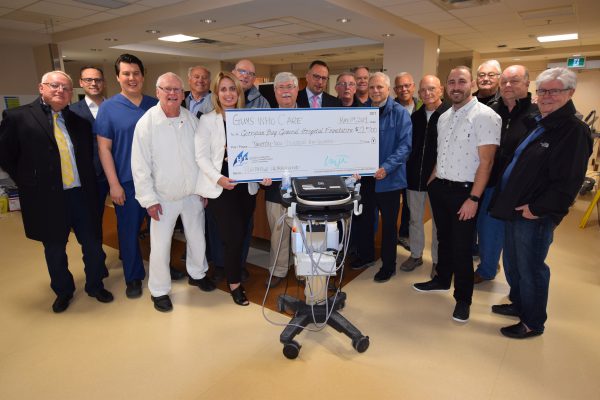 A large group of men with a giant cheque presenting it to the GBGN foundation
