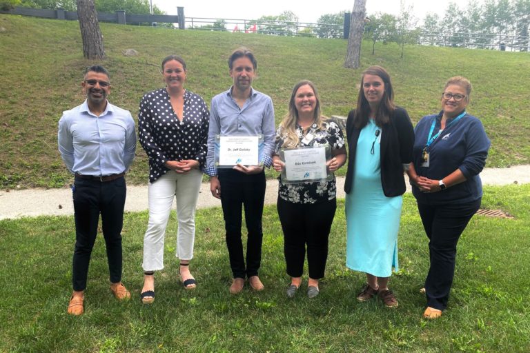 Four women and two men pose outside. Dr. Golisky and Erin Kominek both old us certificate for the Hartog Award.