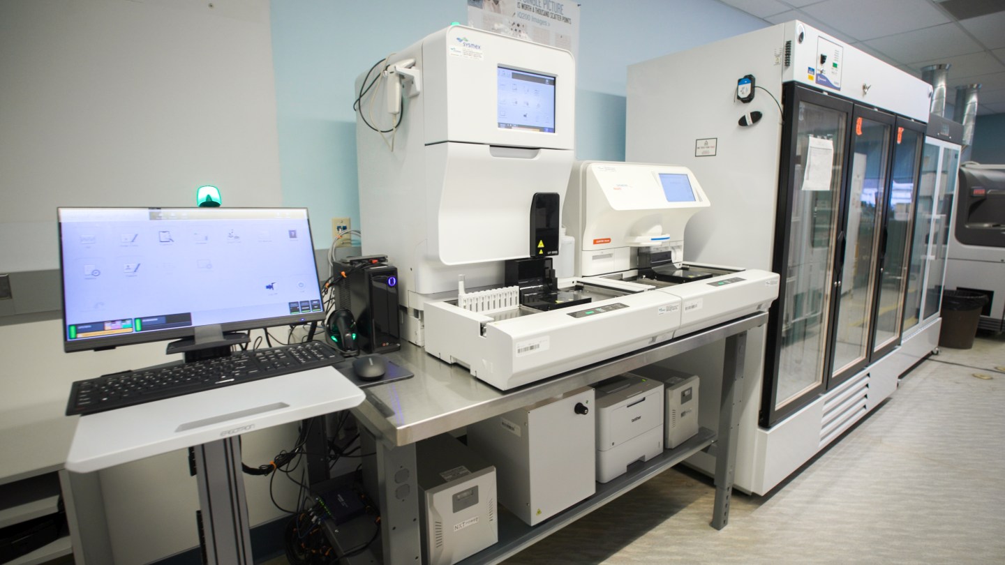 A large lab analyzer machine with a computer monitor on the left