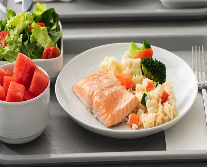 Salmon with rice and vegetable served with salad and watermelon