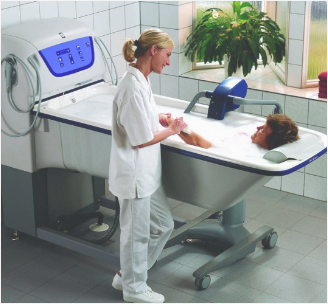 Patient in a hospital bathtub with a nurse attending