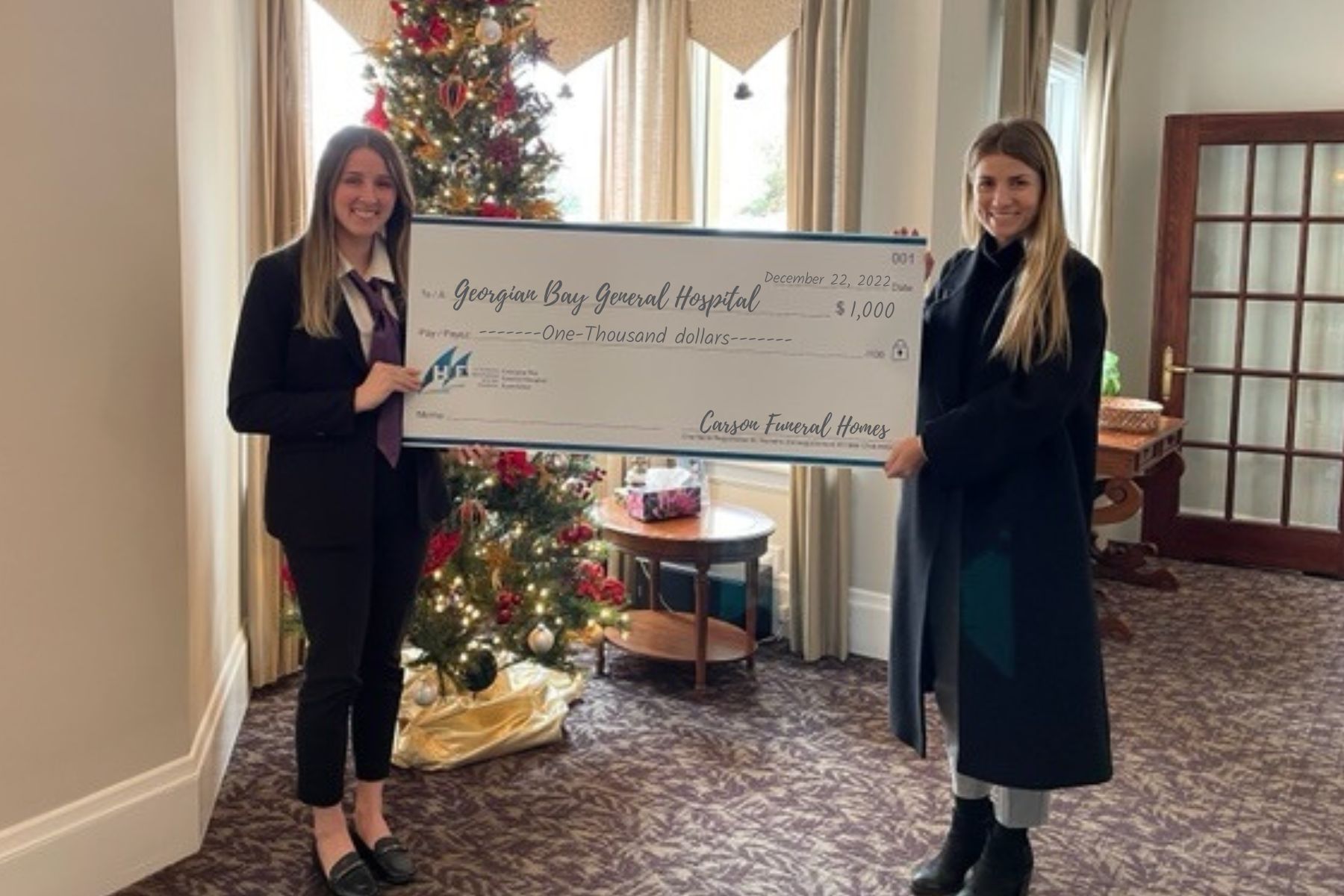 Two women holding a giant cheque to GBGH for $1,000 from Carson Funeral Homes
