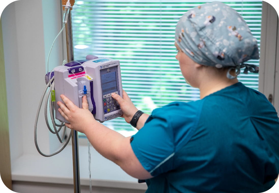 A female medical worker checking vitals on a piece of equipment